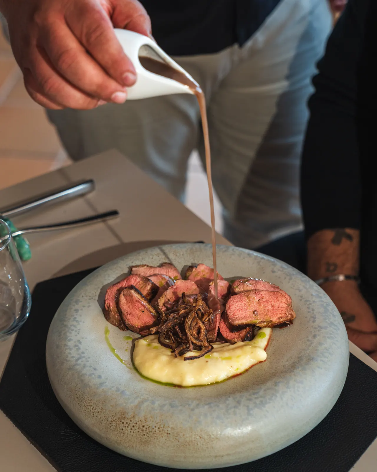 Un secondo di carne con la salsa versata al tavolo