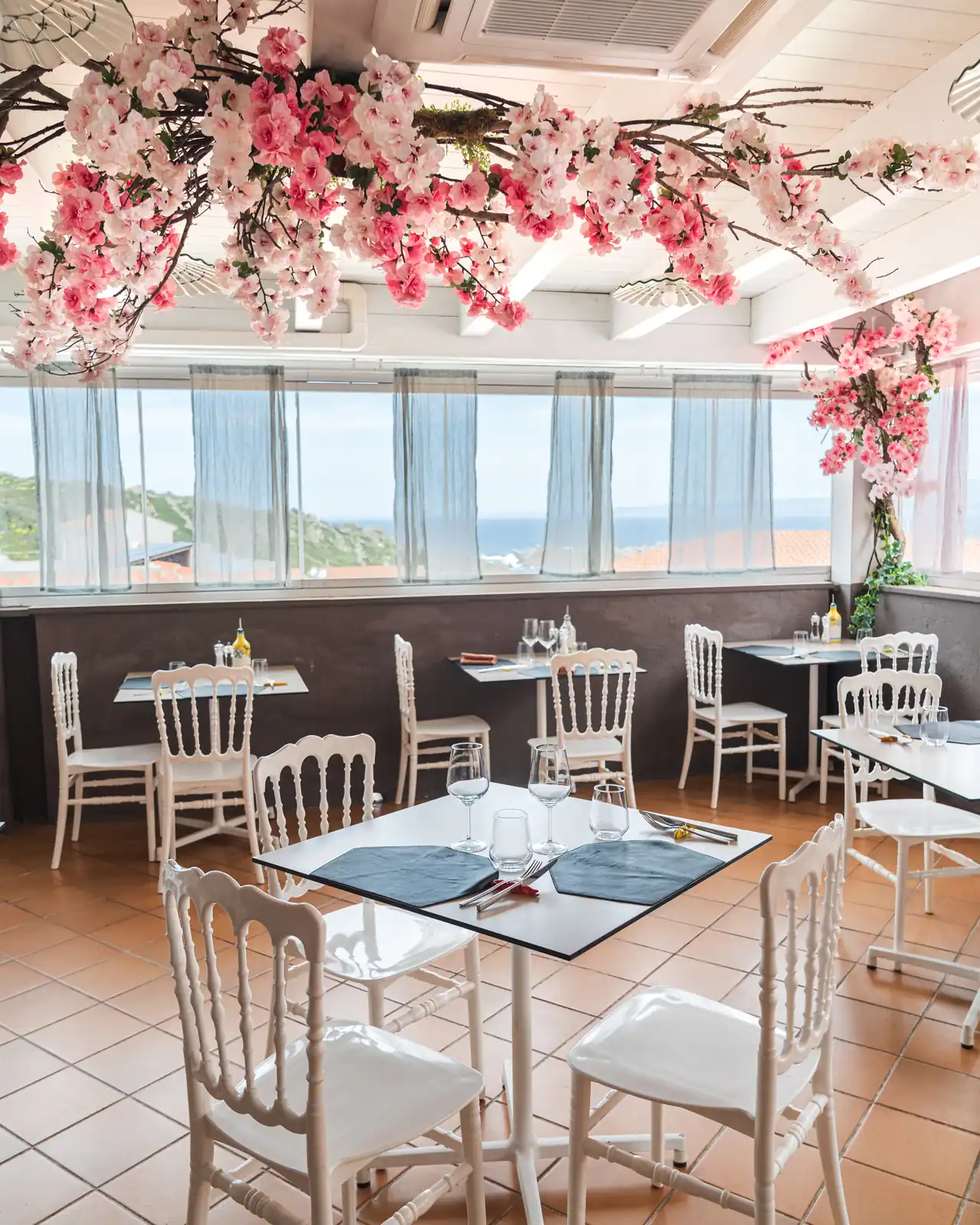 La sala interna con i tavoli bianchi e i fiori