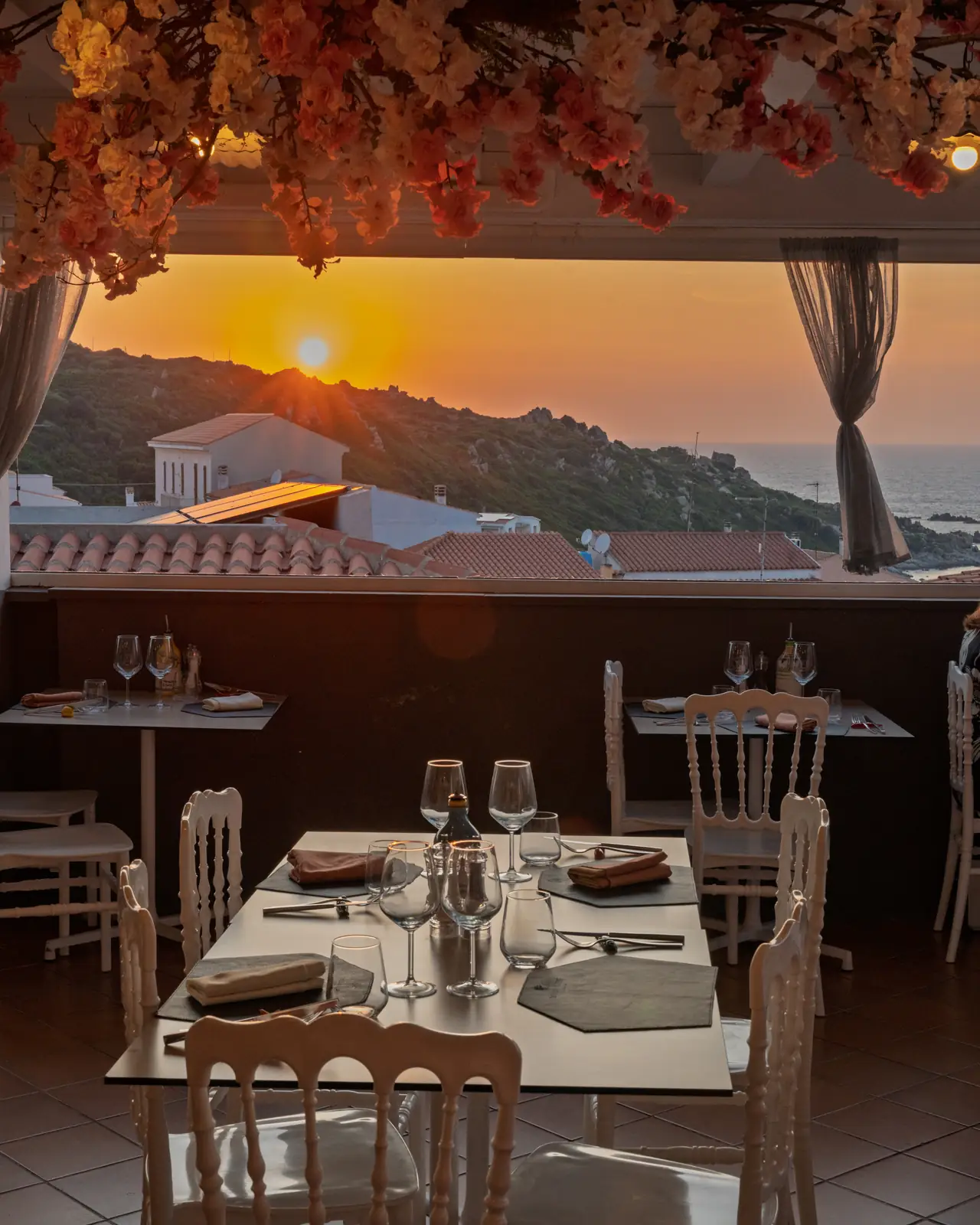 Un tavolo apparecchiato con il tramonto sul mare