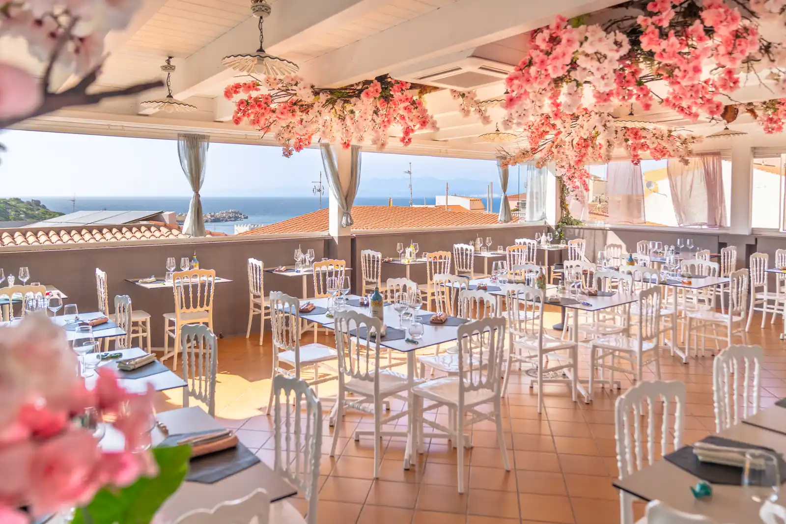 La terrazza di giorno, con i fiori e il mare sullo sfondo
