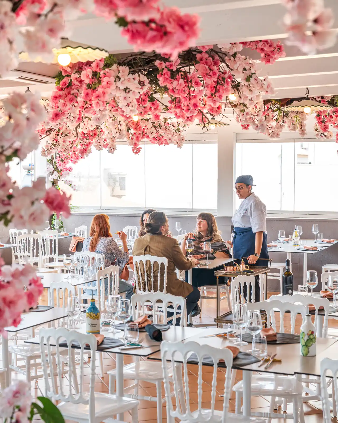 La terrazza di giorno, con gli ospiti ai tavoli e il cameriere in sala