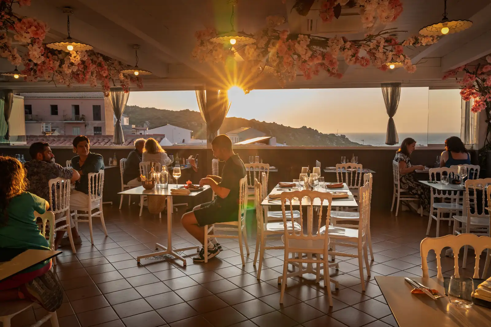 La terrazza al tramonto con gli ospiti ai tavoli